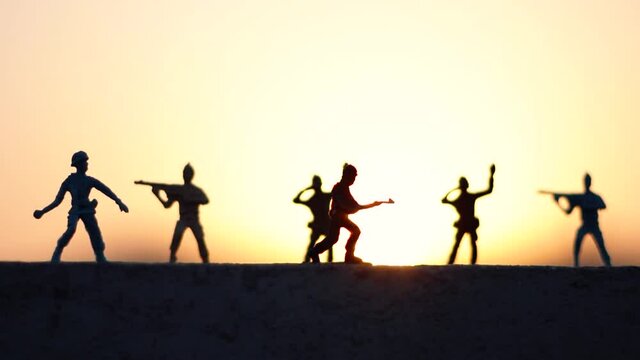Silhouette shot of toy soldiers in front of the sunset