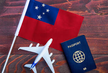 Flag of Samoa with passport and toy airplane on wooden background. Flight travel concept 