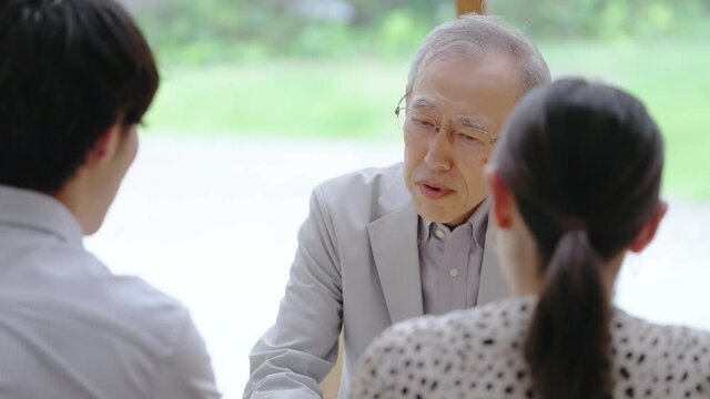 会話をするシニア男性と若い男女