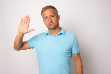 Fototapeta premium Young handsome man with blue eyes wearing casual clothes standing over white background doing stop sing with palm of the hand