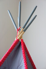Vertical shot of a wigwam tent with wooden sticks © Mirco Vacca/Wirestock