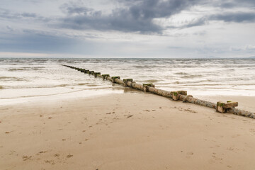 Sewage or waste water discharge pipe leading out to sea on a beach