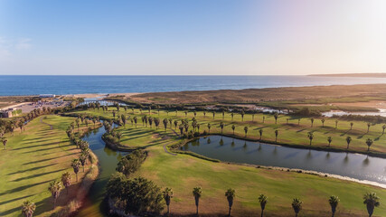 Green golf courses by the sea. Salgados beach. Portugal, Albufeira. Aerial view.