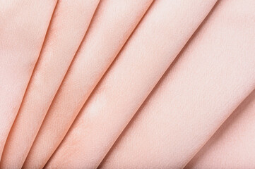 Elegant coral silk fabric background with waves. Close up abstract background luxury cloth silver satin. pink color