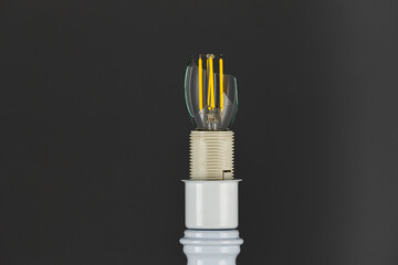 A broken diode lamp in a cartridge on a dark background