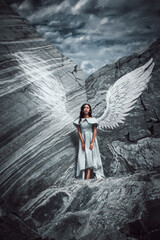 Young woman in long dress with angel wings
