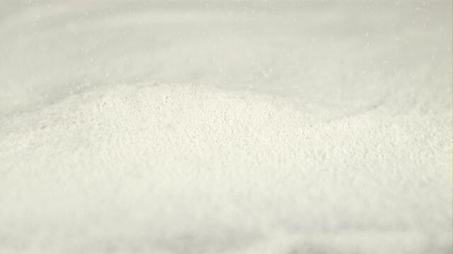 Super slow motion flour is poured into a baking heap. Macro background. Filmed on a high-speed camera at 1000 fps.
