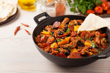 Pork stew with chorizo and black beans. Served with orange and seasoned with hot chili peppers. Perfect with tortillas.