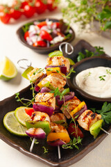 Grilled skewers with chicken, pepper, and onion. Served with sauce. Painted, bright background.