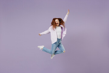 Full size body length crazy pampering young redhead curly green-eyed woman 20s wear white T-shirt violet jacket jumping spreading hands isolated on pastel purple color wall background studio portrait