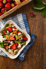 Delicious salad with fried chicken, blue cheese, strawberries and walnuts. Top view.