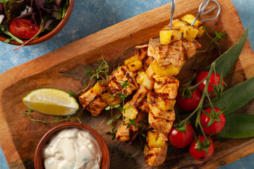 Grilled shashlik with salmon and pineapple. Served with yoghurt sauce.