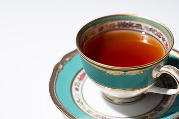 Hot tea in an antique cup and saucer on a white background