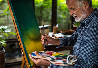 Senior artist painting in a workspace