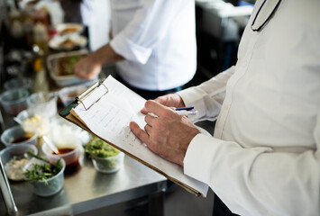 Closeup of chef hand checking menu list