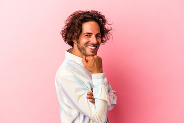 Young caucasian man isolated on pink bakcground smiling happy and confident, touching chin with hand.