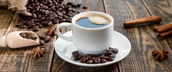 Cup of coffee on a wooden table. The concept of making natural coffee from quality coffee beans. Banner