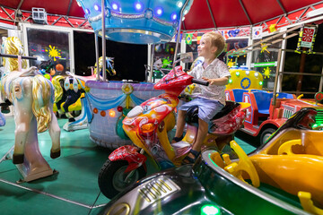 Италия. Казерта. Ребенок катается на карусели в парке аттракционов.     Italy. Caserta. A child rides on a carousel in an amusement park.