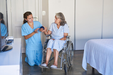Fototapeta premium Seniorin im Rollstuhl bei der Physiotherapie mit dem Igelball