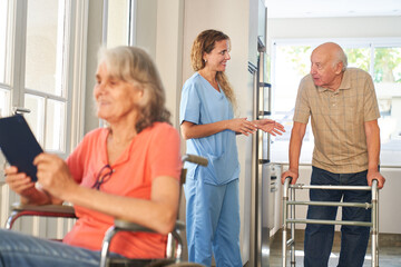 Altenpflegerin spricht mit einem Senior mit Rollator