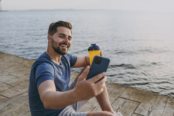 Young sporty strong sportsman man 20s in sports clothes shorts train do selfie shot photo on mobile...