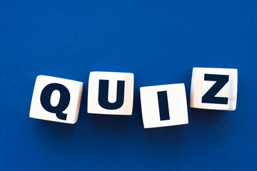 Word quiz. Wooden small cubes with letters isolated on blue background with copy space available. Business Concept image.