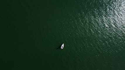 Aerial drone view of sailing boat on a river.
