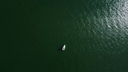 Fototapeten Aerial drone view of sailing boat on a river. © astrosystem