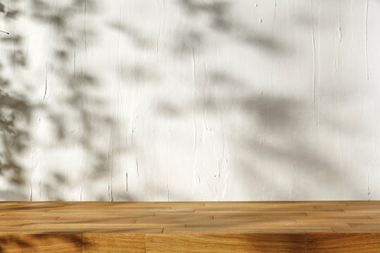 Wooden desk of free space for your decoration and wall with shadows. 