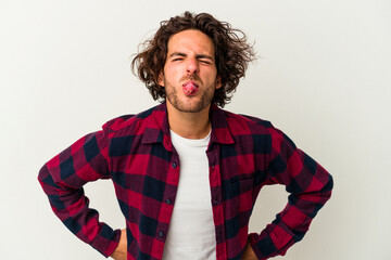 Young caucasian man isolated on white background funny and friendly sticking out tongue.