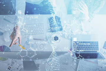 Double exposure of man and woman working together and DNA hologram drawing. Computer background. Medical education concept. Top View.