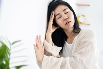 Asian woman having problem with Meniere's disease, fainting or dizziness hand holding her head...
