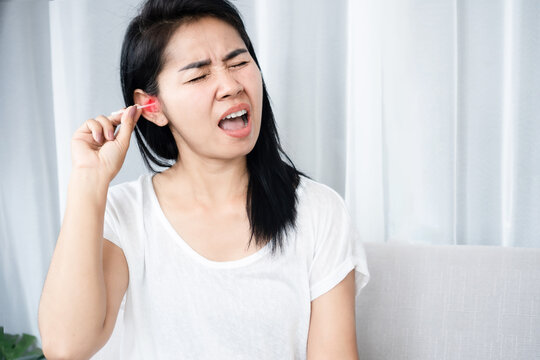 Asian woman hurts from cleaning  ear wax by cotton bud that put too deep inside her ear