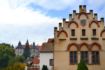 Obraz premium One of the streets of Žleby town with medieval old building and Žleby Castle in the foreground. Central Bohemian region, Czech Republic
