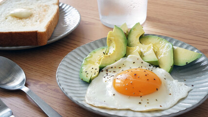 食パンに添えられた半熟の目玉焼きとアボカド