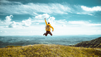 Hiker with backpack raising hands jumping on the top of a mountain - Successful man with arms up enjoying victory - Sport and success concept	
 - Powered by Adobe