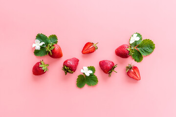 Red ripe strawberries with leaves and flowers. Top view