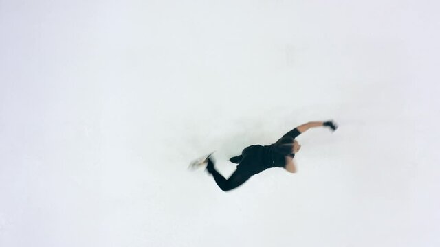 A girl is doing spinning exercises while skating in a top view