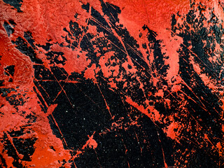 Spilled paint on the asphalt. Grunge texture with splashes and stones. Dark background with bright spots