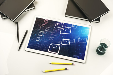 Top view of modern digital tablet monitor with postal envelopes hologram. Electronic mail and spam...