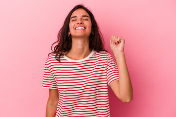 Young caucasian woman isolated on pink background celebrating a victory, passion and enthusiasm,...