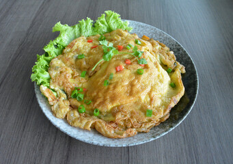 golden stir fried egg omelette with seafood and meat on wood table asian Thai appetiser halal menu