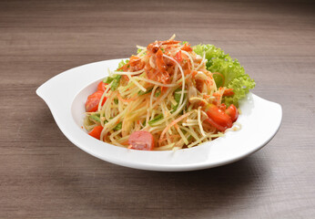 cold thai style spicy chilli sauce papaya and mango vegetable salad and shrimp in bowl on wood table asian Thai appetiser halal menu