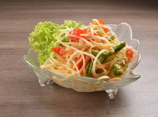 cold thai style spicy chilli sauce papaya and mango vegetable salad and shrimp in bowl on wood table asian Thai appetiser halal menu