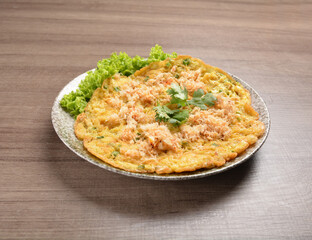golden stir fried egg omelette with seafood and meat on wood table asian Thai appetiser halal menu