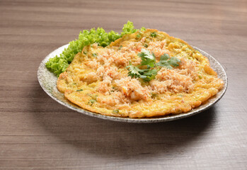 golden stir fried egg omelette with seafood and meat on wood table asian Thai appetiser halal menu