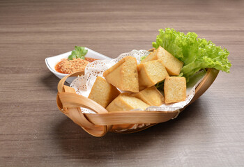 deep fried seafood bean curd tofu in basket with spicy chilli sauce on wood table asian Thai appetiser halal menu