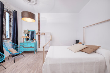 Fototapeta na wymiar Dormitorio en apartamento vacacional con tocador azul y butacas azules. Decoracion chic para viajeras.