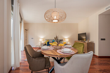 Dining table in apartment with full fruit bowl and glasses with orange juice.