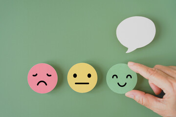 human's hand holding happy smile face paper cut with speech bubble on , satisfaction survey ,good...